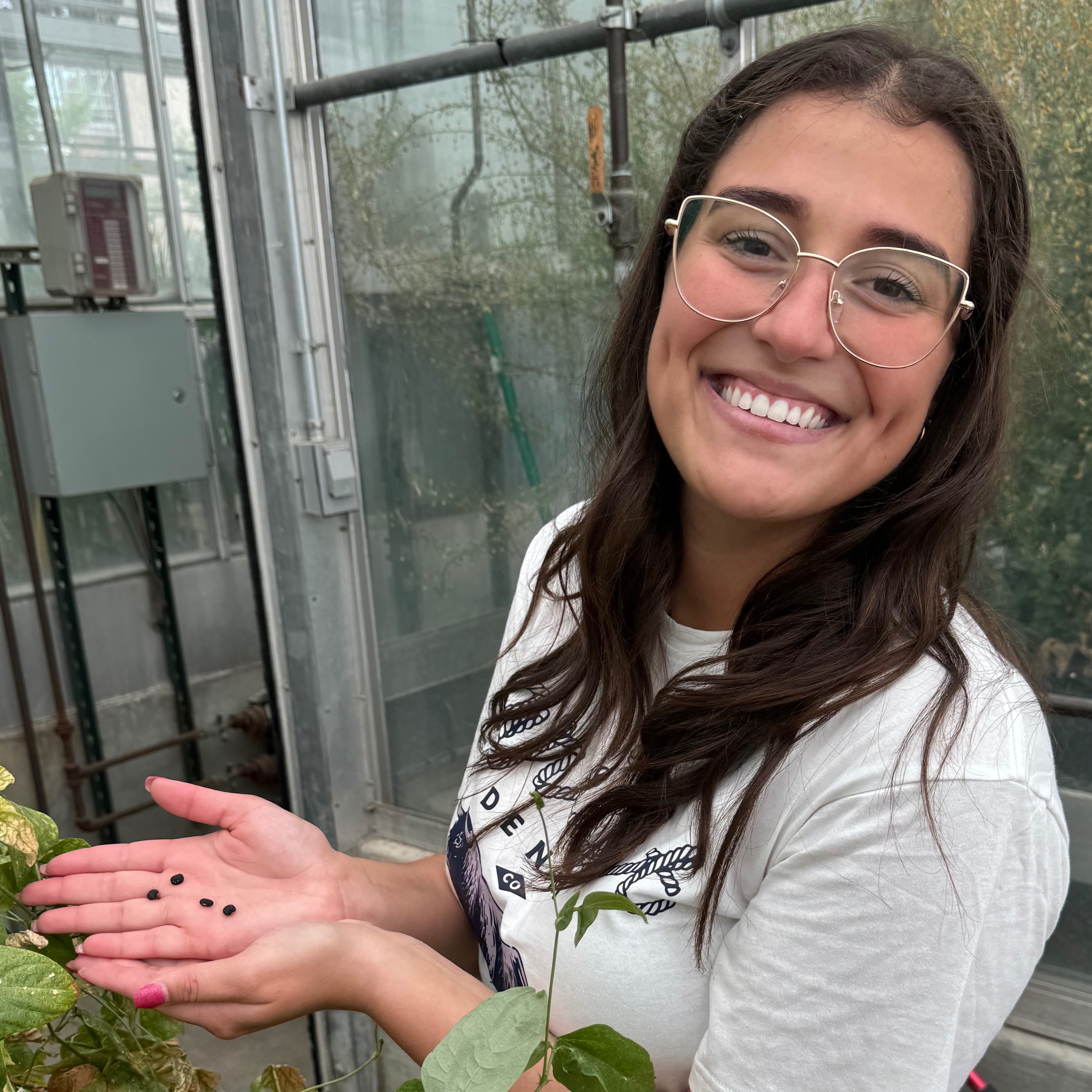 Alethia Pratas da Costa Braun smiles while holding small black seeds