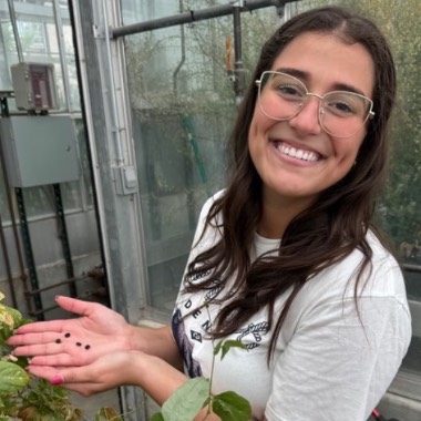 Alethia Pratas da Costa Braun smiles while holding small black seeds